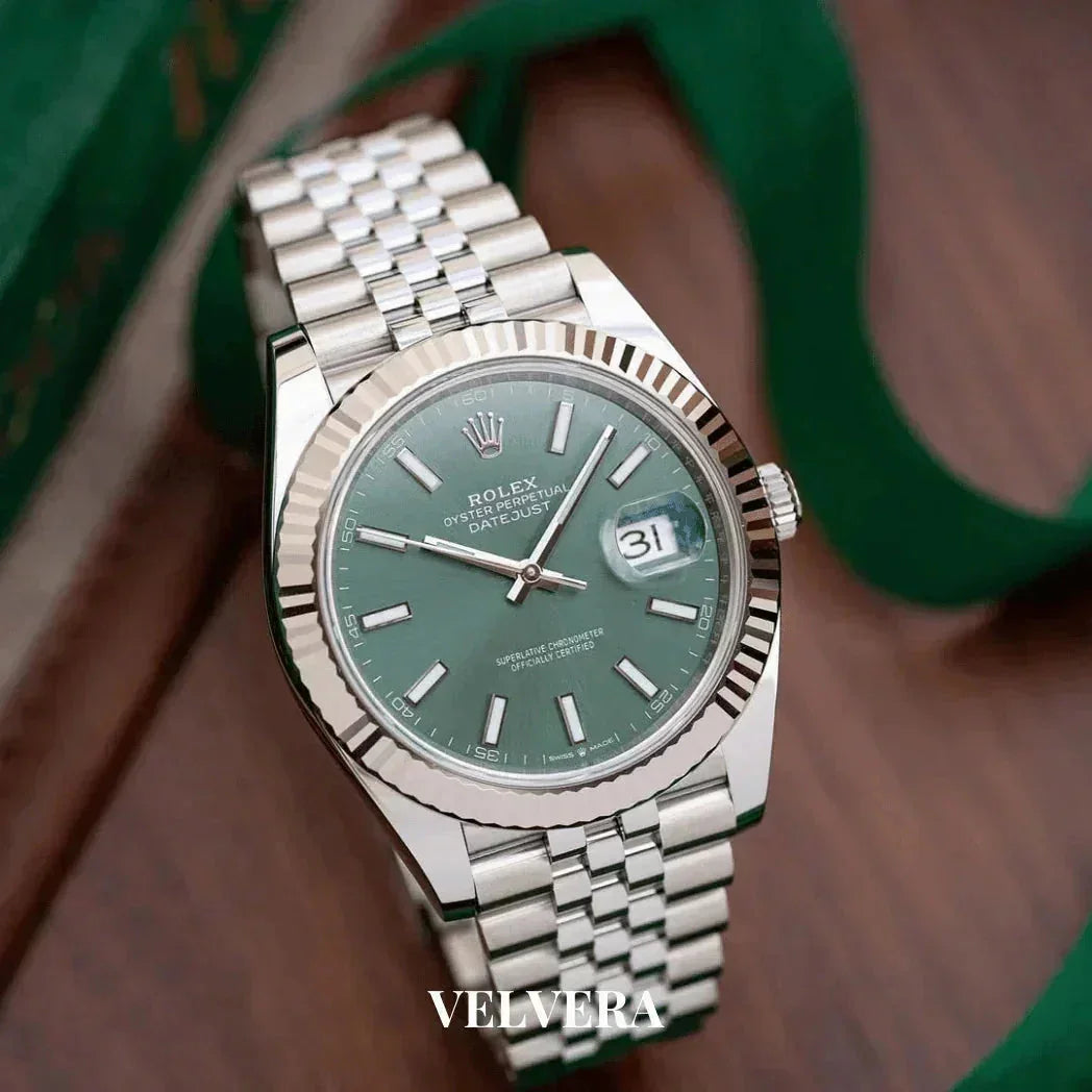Rolex Oyster Perpetual Datejust green dial luxury watch with silver bracelet on wood background