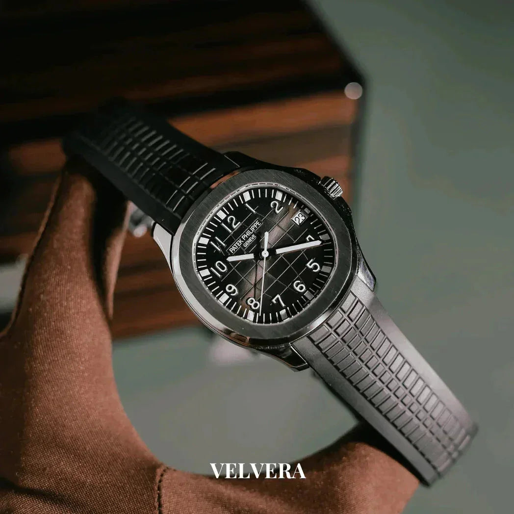 Black Patek Philippe Aquanaut watch with rubber strap held by gloved hand, Velvera branding