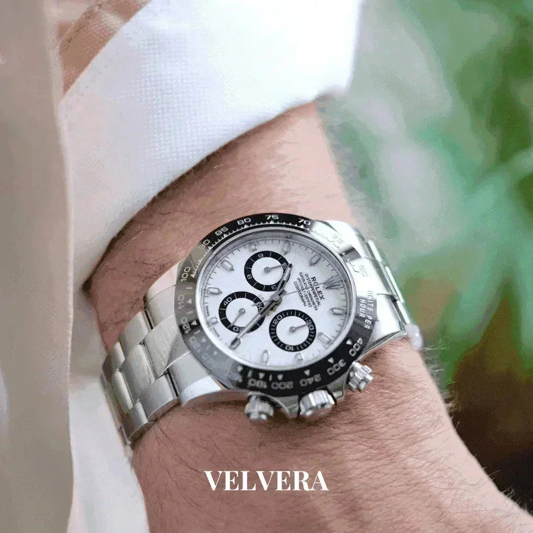 Stainless steel Rolex Daytona watch with white dial on wrist, VELVERA branding visible