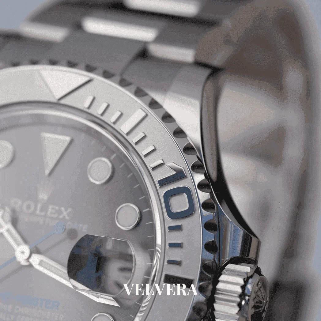 Close-up of silver Rolex Yacht-Master watch bezel, bracelet, and crown, Velvera branding