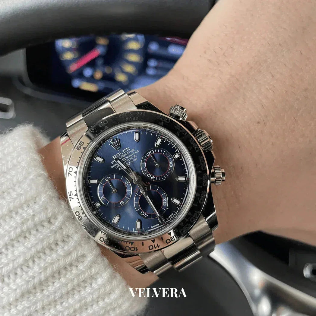Blue dial Rolex Daytona chronograph watch on wrist, driving, VELVERA branding