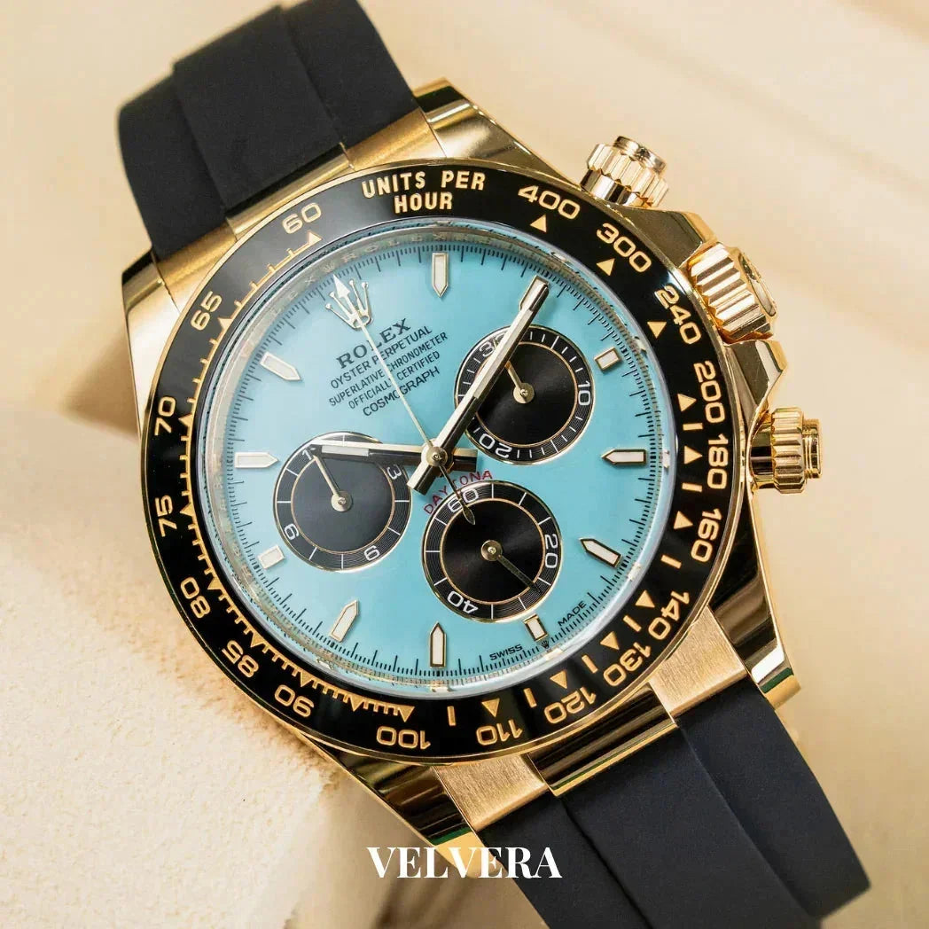 Gold chronograph watch with blue dial, black bezel, black strap, and Velvera branding