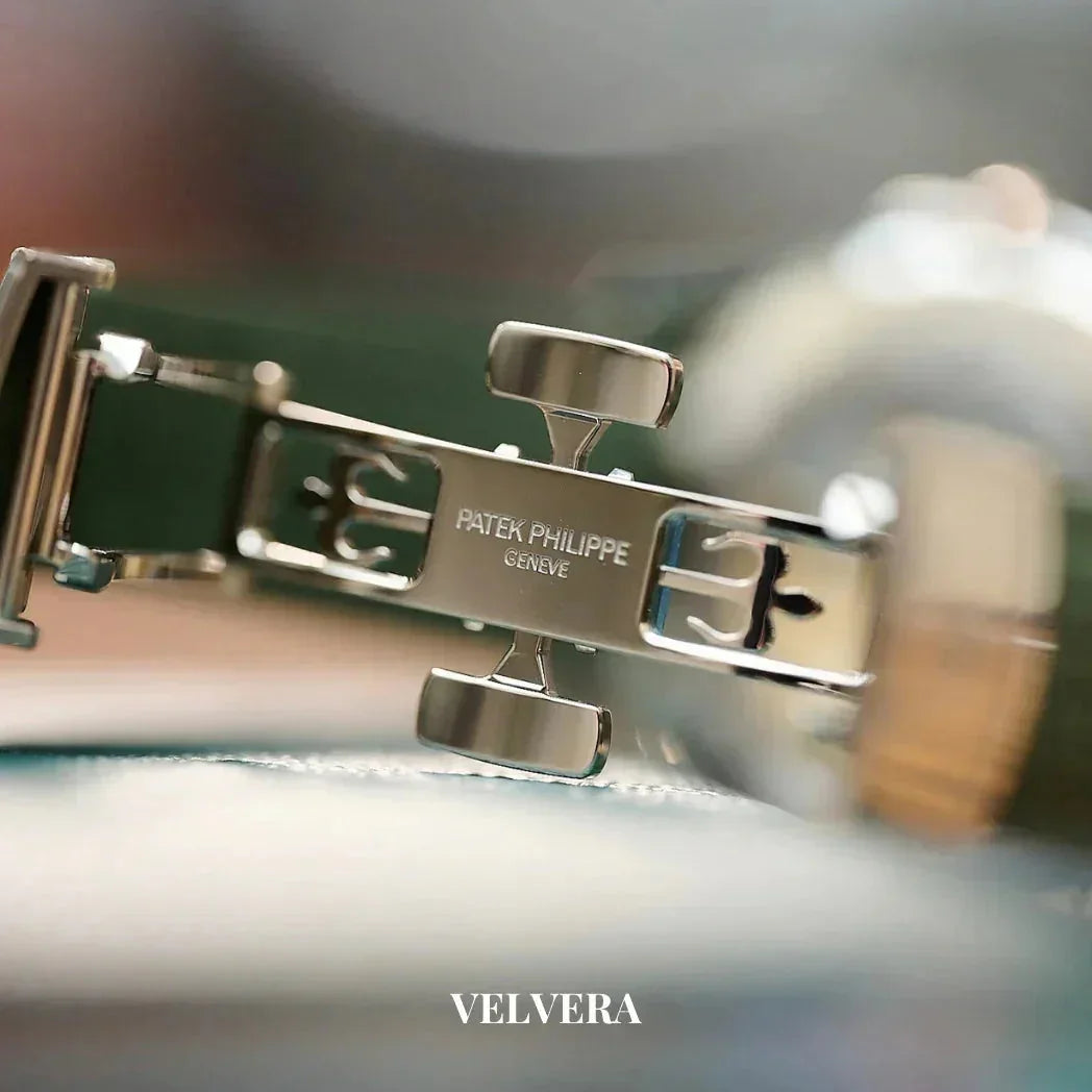 Close-up of Patek Philippe Genève watch clasp on a blurred background, Velvera branding.