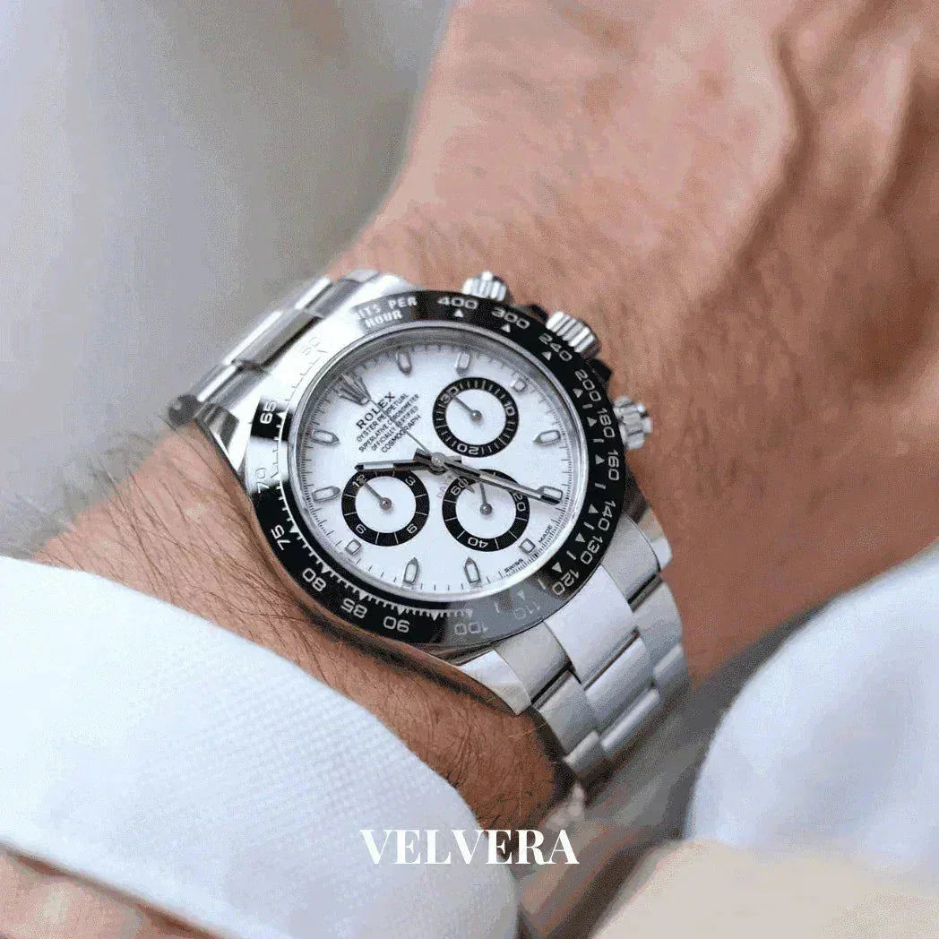 Luxury Rolex Daytona stainless steel watch with black bezel on wrist, VELVERA branding visible.