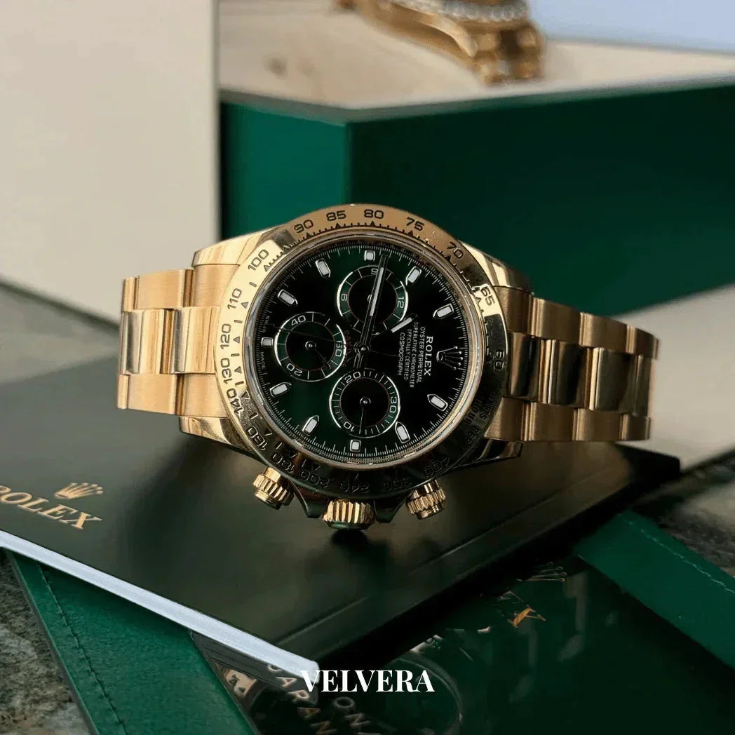 Gold Rolex Daytona watch with black dial on green box and documents, luxury timepiece display