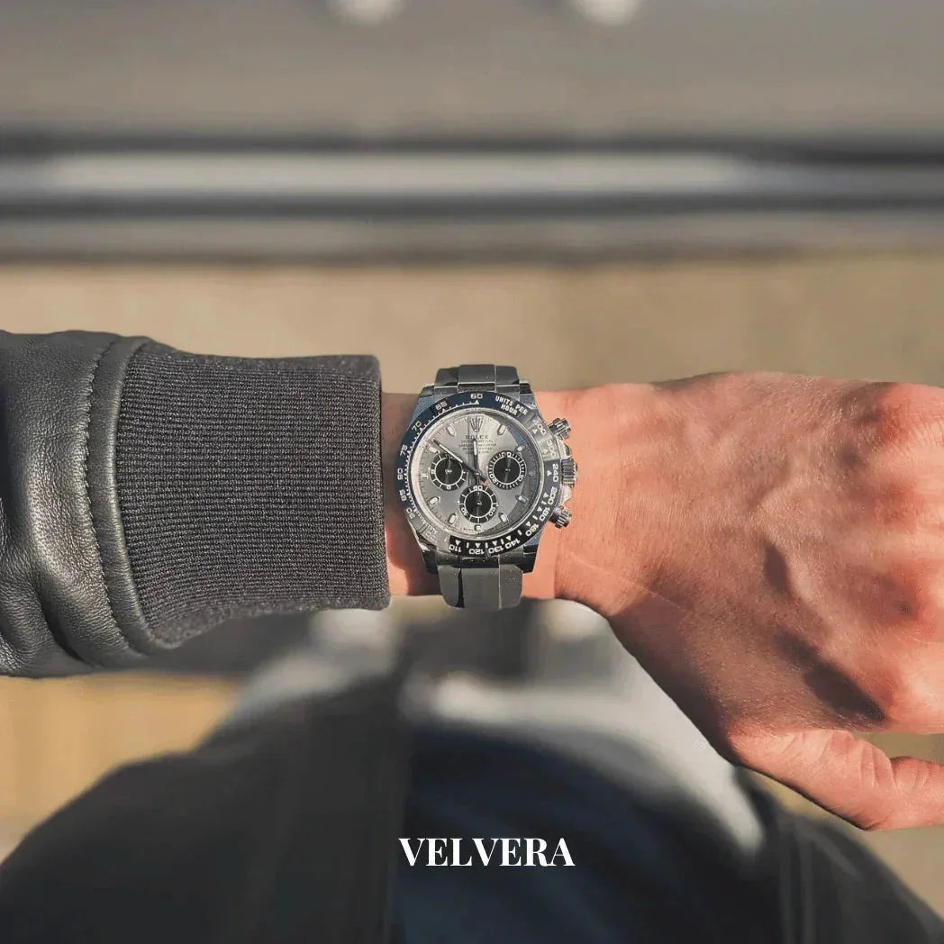Man wearing a luxury silver chronograph watch with black strap outdoors, Velvera branding