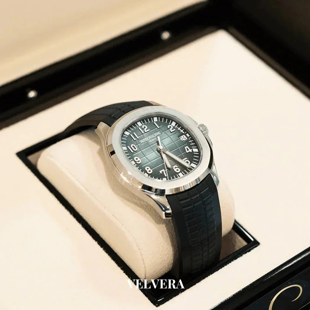 Luxury Patek Philippe watch with black strap displayed on cream velvet cushion in gift box