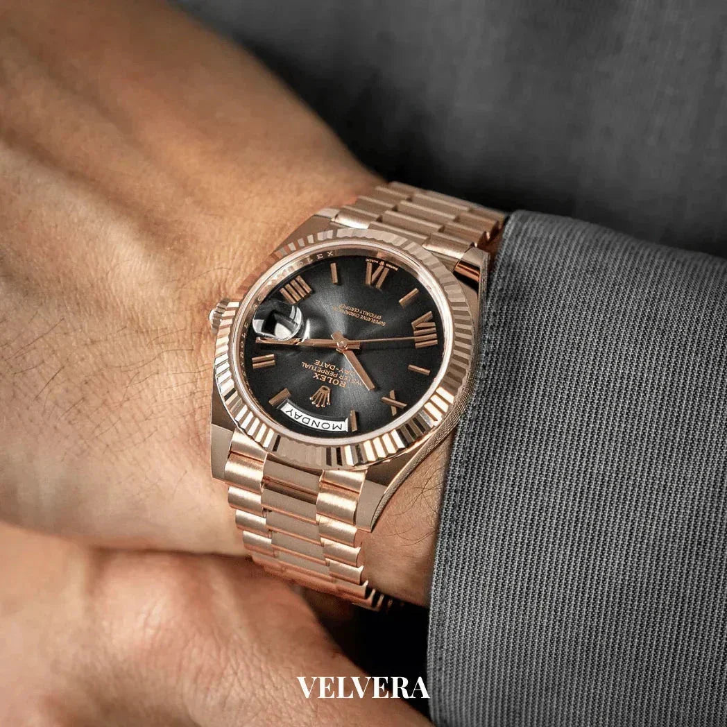 Rose gold Rolex watch with black dial and Roman numerals on a man's wrist, VELVERA branding