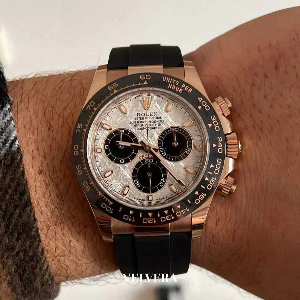 Rolex Daytona rose gold chronograph watch with black ceramic bezel and rubber strap on wrist