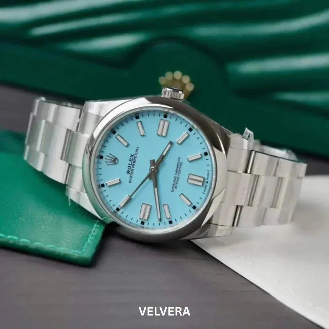 Rolex Oyster Perpetual watch with turquoise blue dial and stainless steel bracelet on table