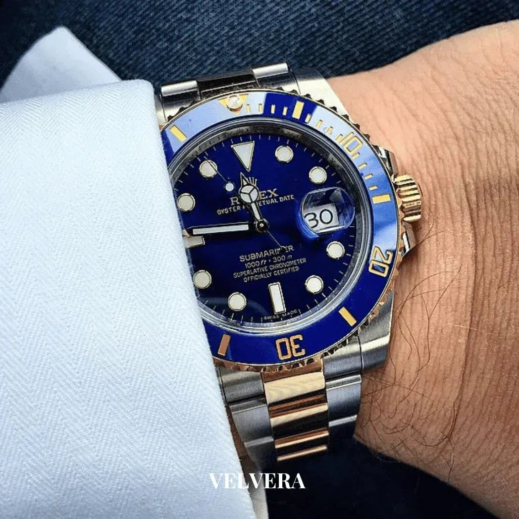 Rolex Submariner blue dial and bezel two-tone watch on wrist, white cuff visible