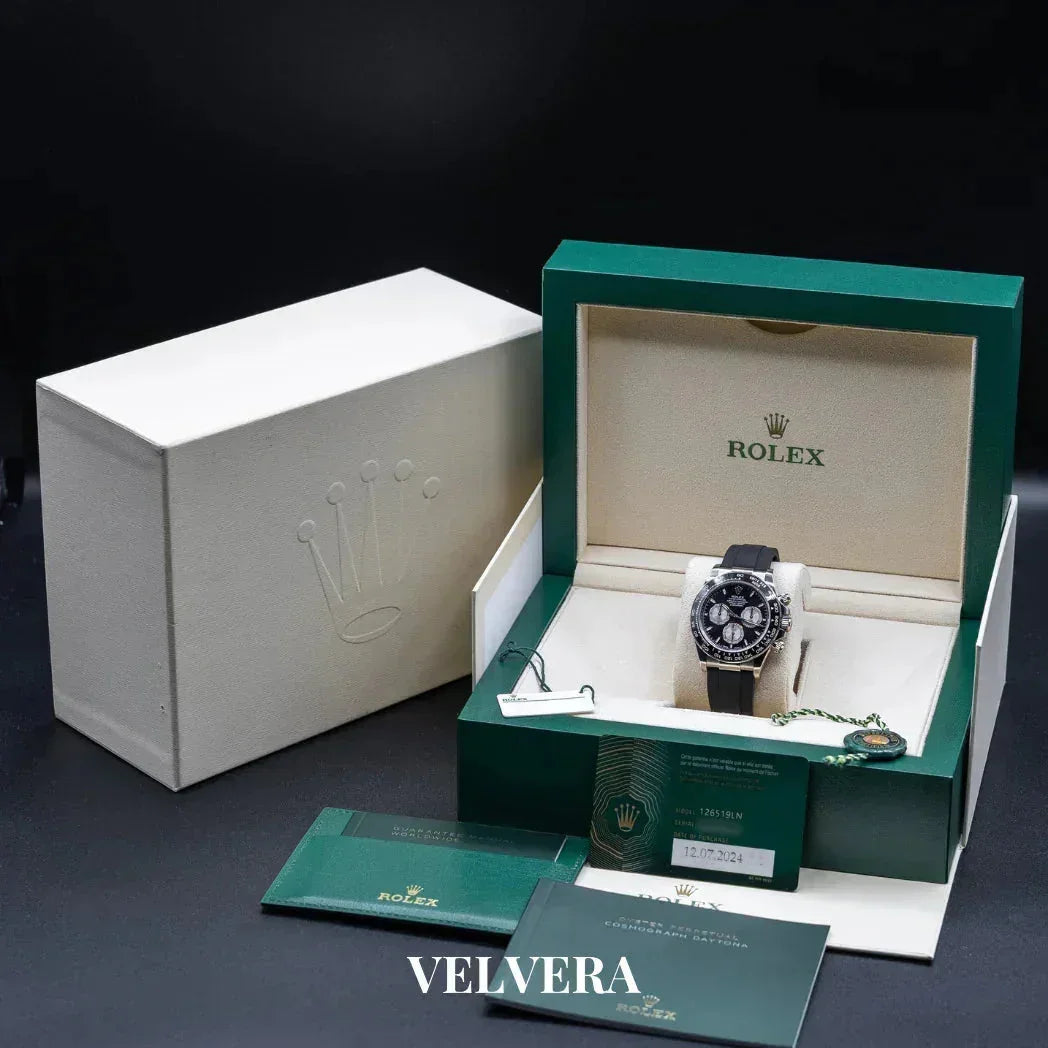 Rolex Daytona watch in green box with warranty card, tags, and outer white case, luxury branding