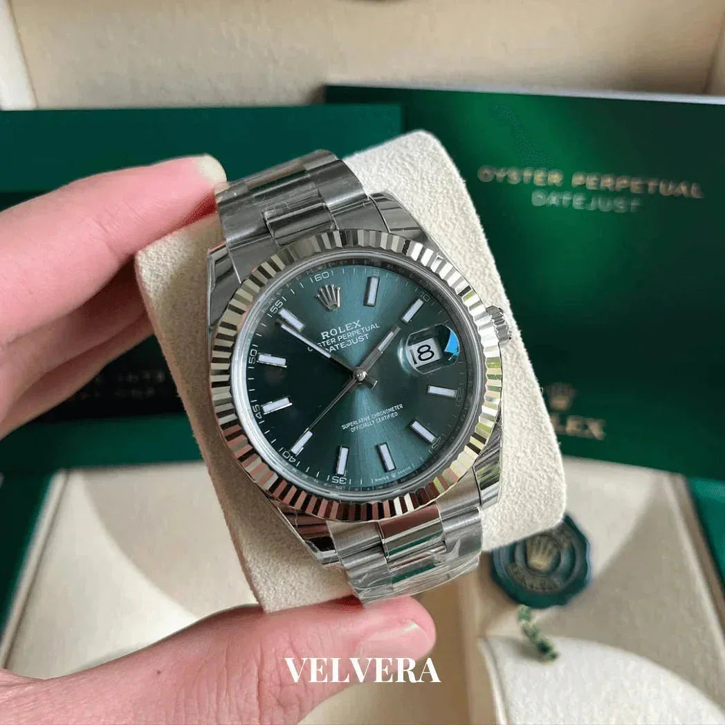 Rolex Datejust watch with green dial and silver bracelet displayed in original packaging
