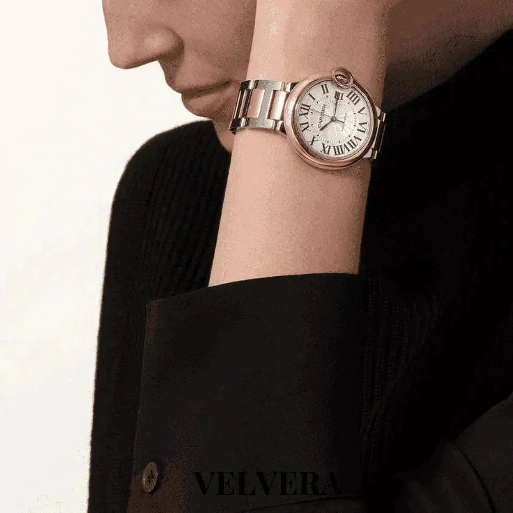 Woman wearing a Ballon Bleu rose gold and steel watch by Velvera with Roman numerals.