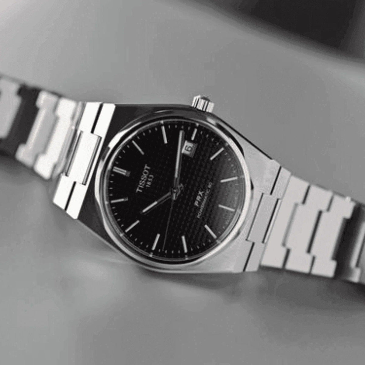 Men’s Tissot PRX Powermatic 80 watch with black dial and silver metal bracelet.