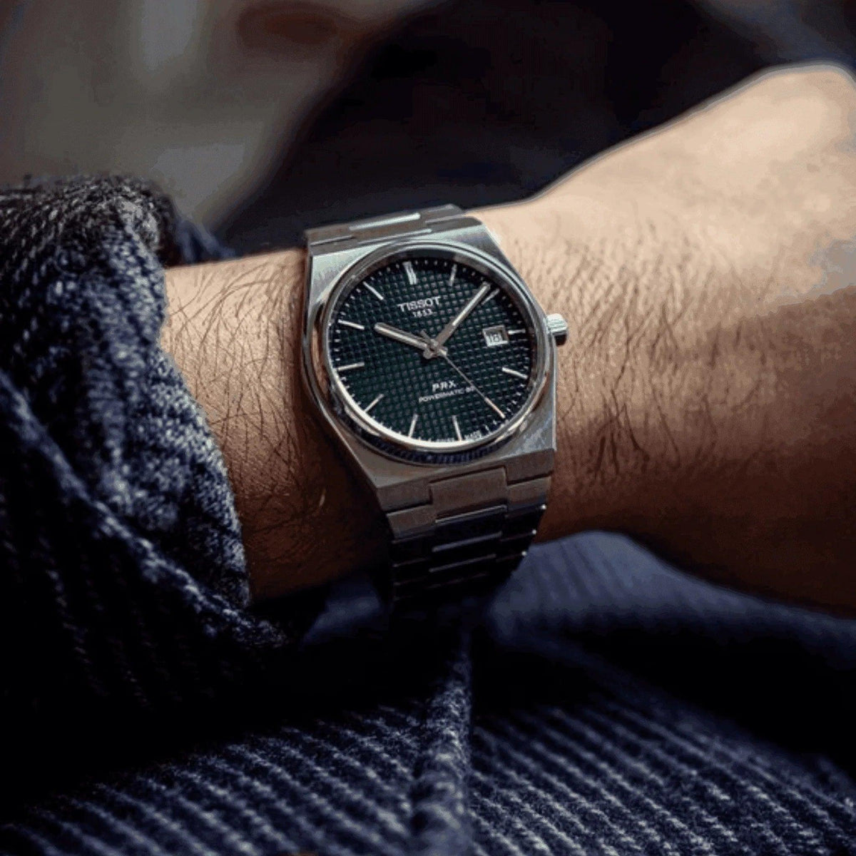 Tissot PRX Powermatic 80 men's watch with green dial on wrist, stainless steel bracelet