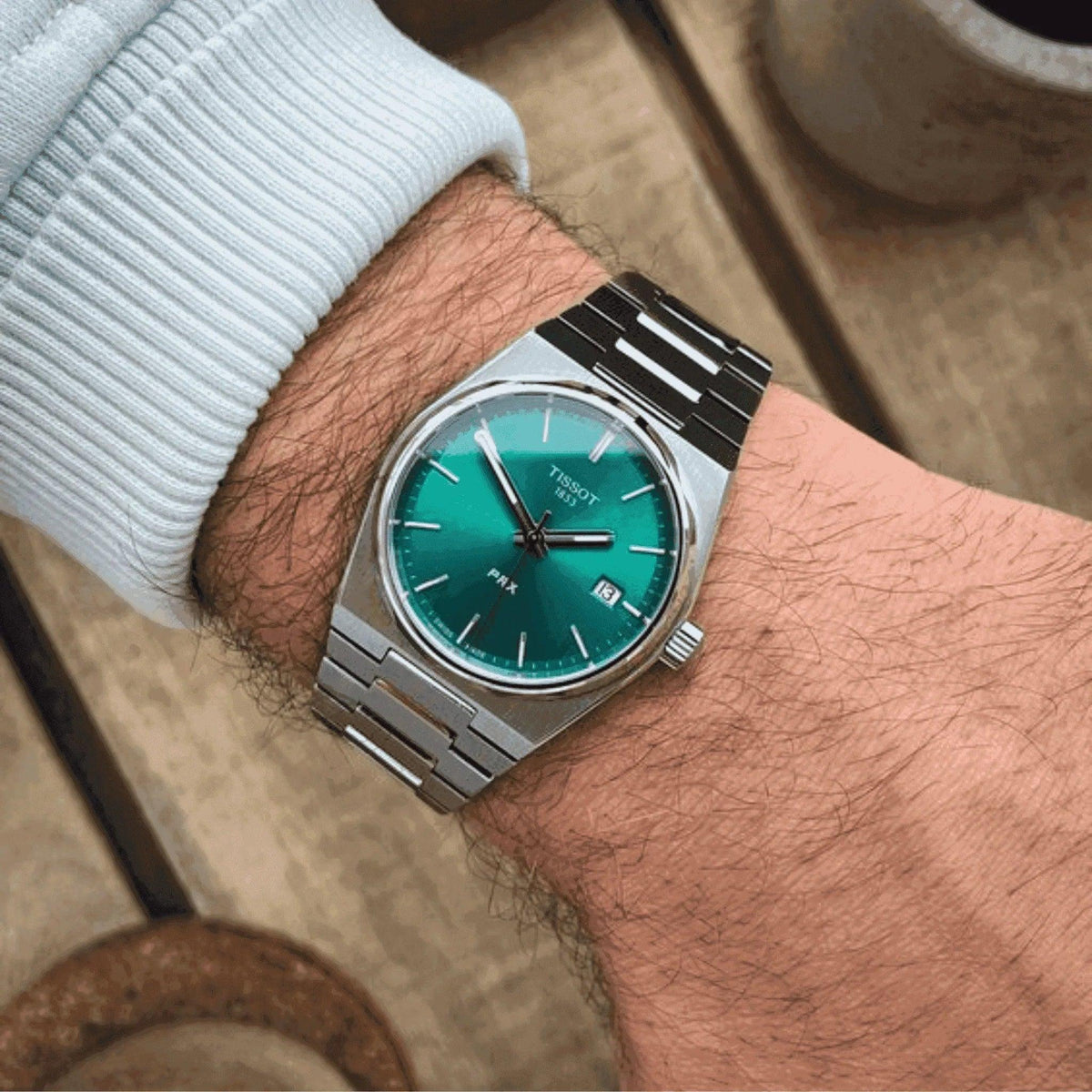 Tissot PRX Powermatic 80 men's watch with green dial and stainless steel bracelet on wrist