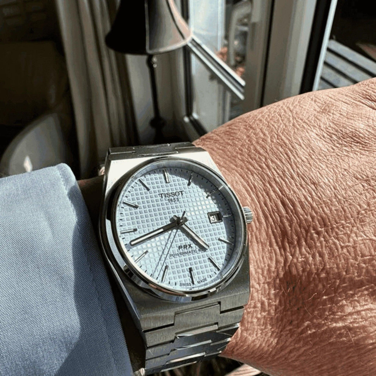 Tissot PRX Powermatic 80 ice blue men's watch with stainless steel bracelet on wrist