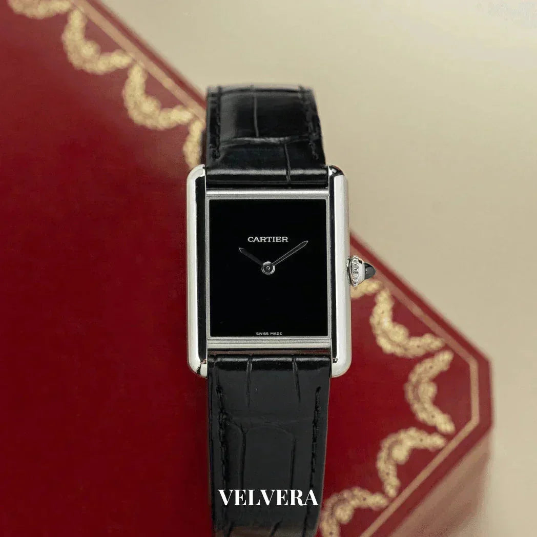 Cartier Tank watch with black leather strap on red decorative box, luxury Swiss timepiece