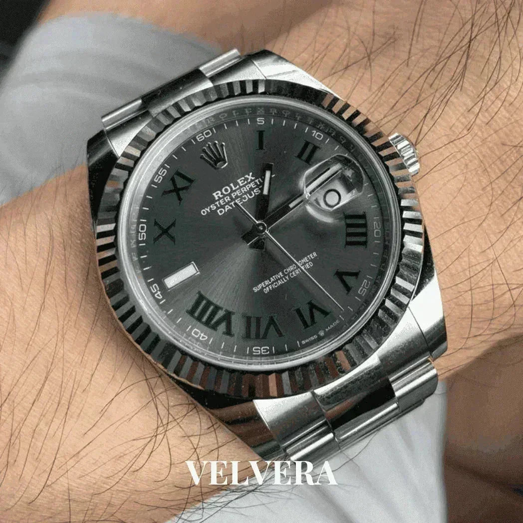 Rolex Datejust silver stainless steel watch with black dial and Roman numerals on wrist