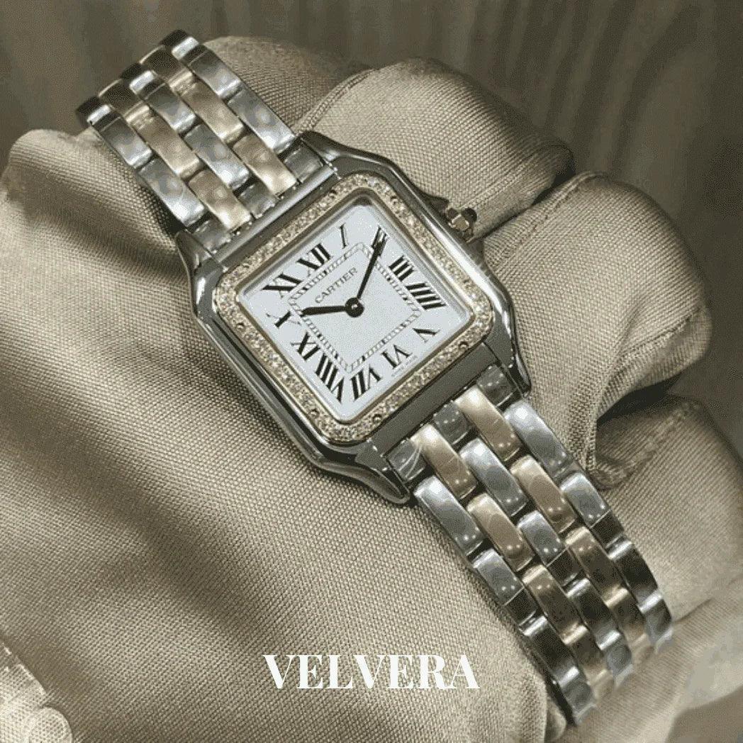 Luxury Cartier silver watch with Roman numerals held by gloved hand, VELVERA branding