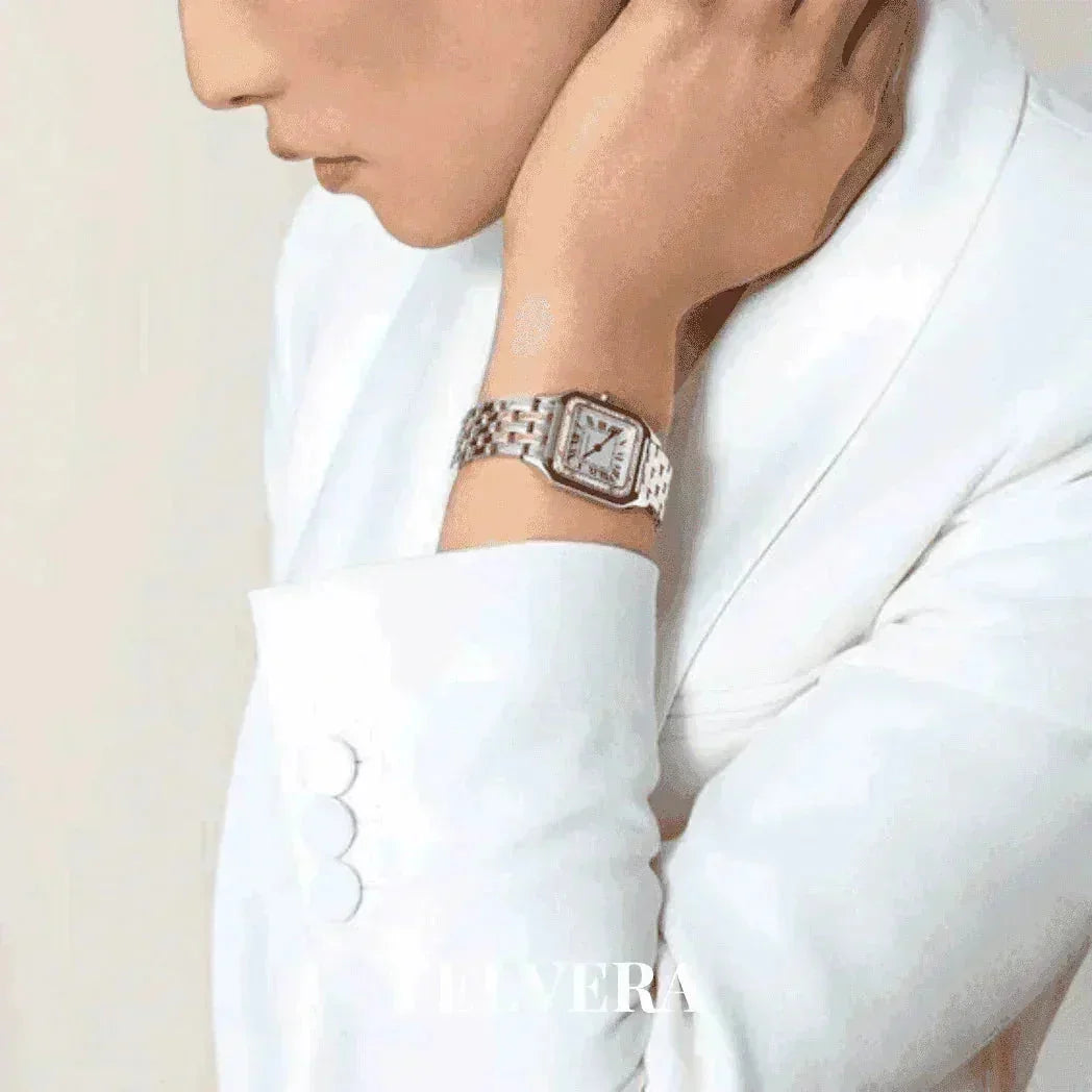 Woman in white suit wearing luxury silver wristwatch, modern fashion style