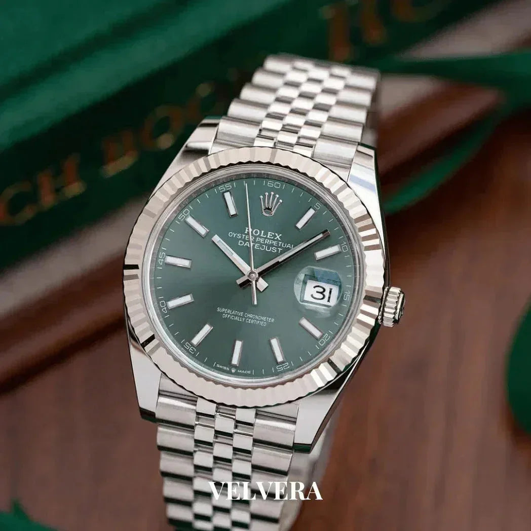Rolex Datejust green dial watch with silver jubilee bracelet on wooden surface, Velvera branding