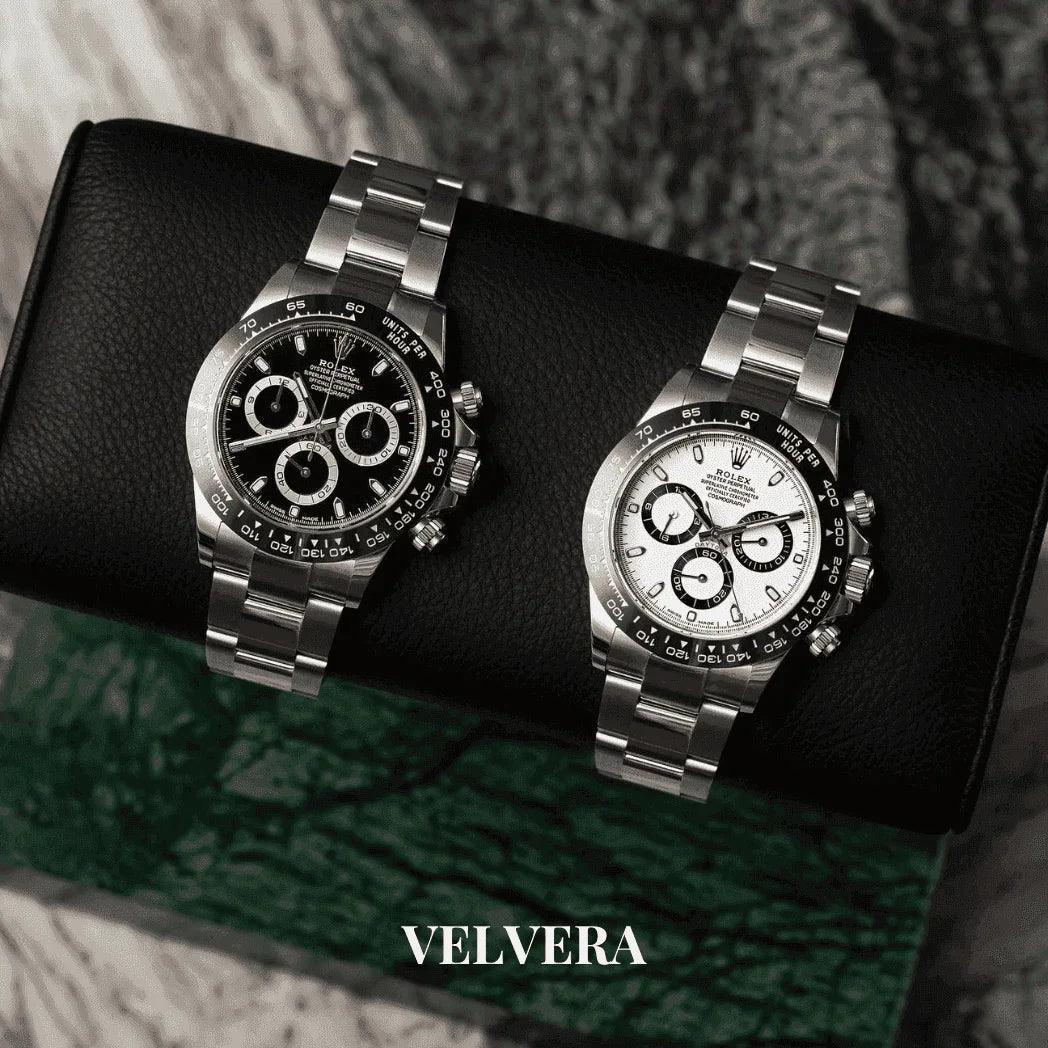 Two luxury Rolex Daytona watches with black and white dials on a leather watch roll, VELVERA