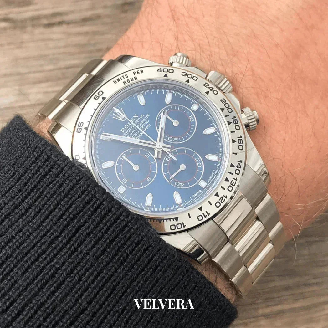 Silver Rolex Daytona watch with blue dial on wrist, stainless steel bracelet, close-up