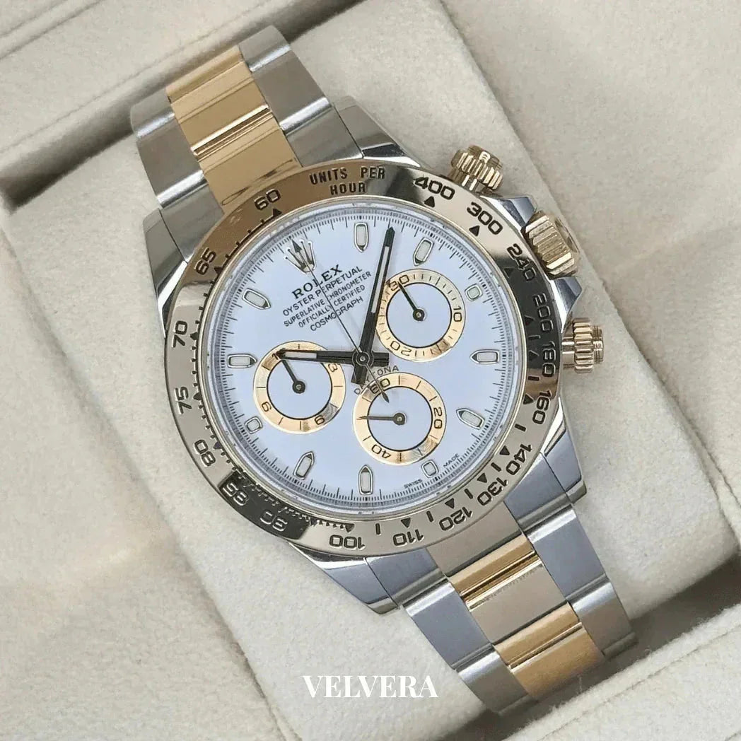 Luxury two-tone Rolex Daytona watch with gold and silver band on cream display, Velvera branding
