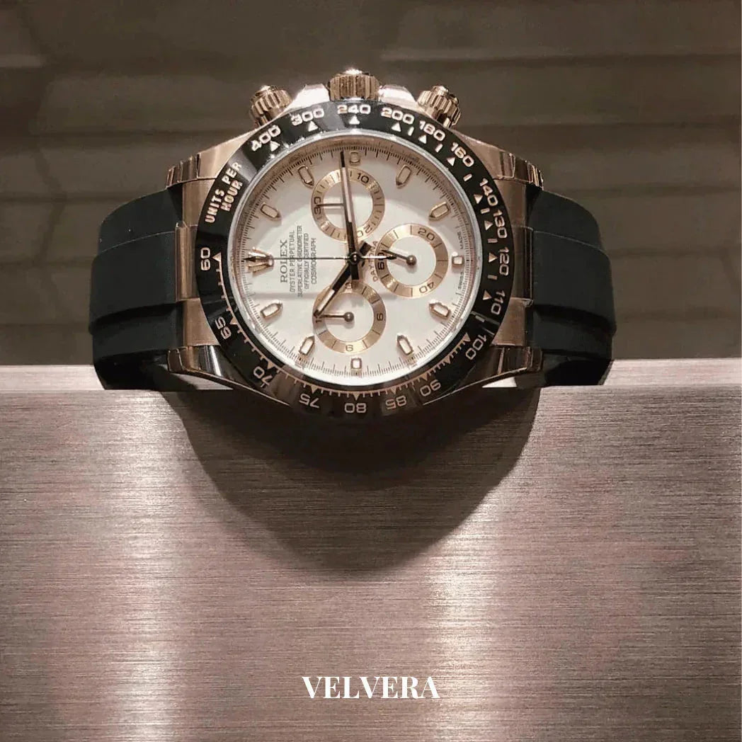 Luxury Rolex chronograph watch with white dial, gold accents, black bezel and rubber strap on display