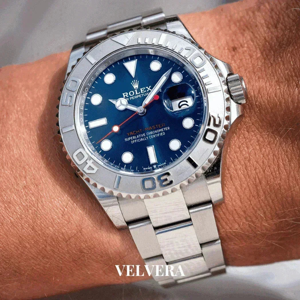 Silver Rolex Yacht-Master watch with blue dial on wrist, Velvera branding visible