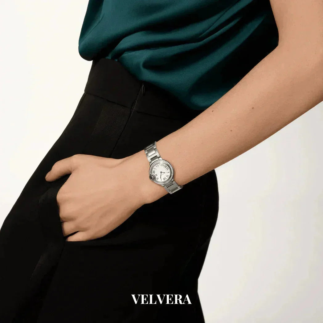 Woman wearing a silver VELVERA wristwatch with white dial and metal band, hand in pocket