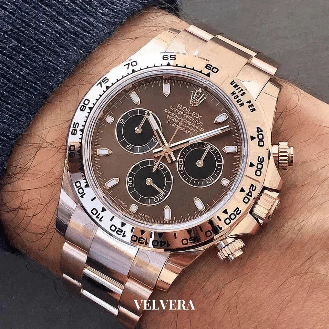 Rose gold Rolex Daytona chronograph watch with brown dial on wrist, luxury men's accessory