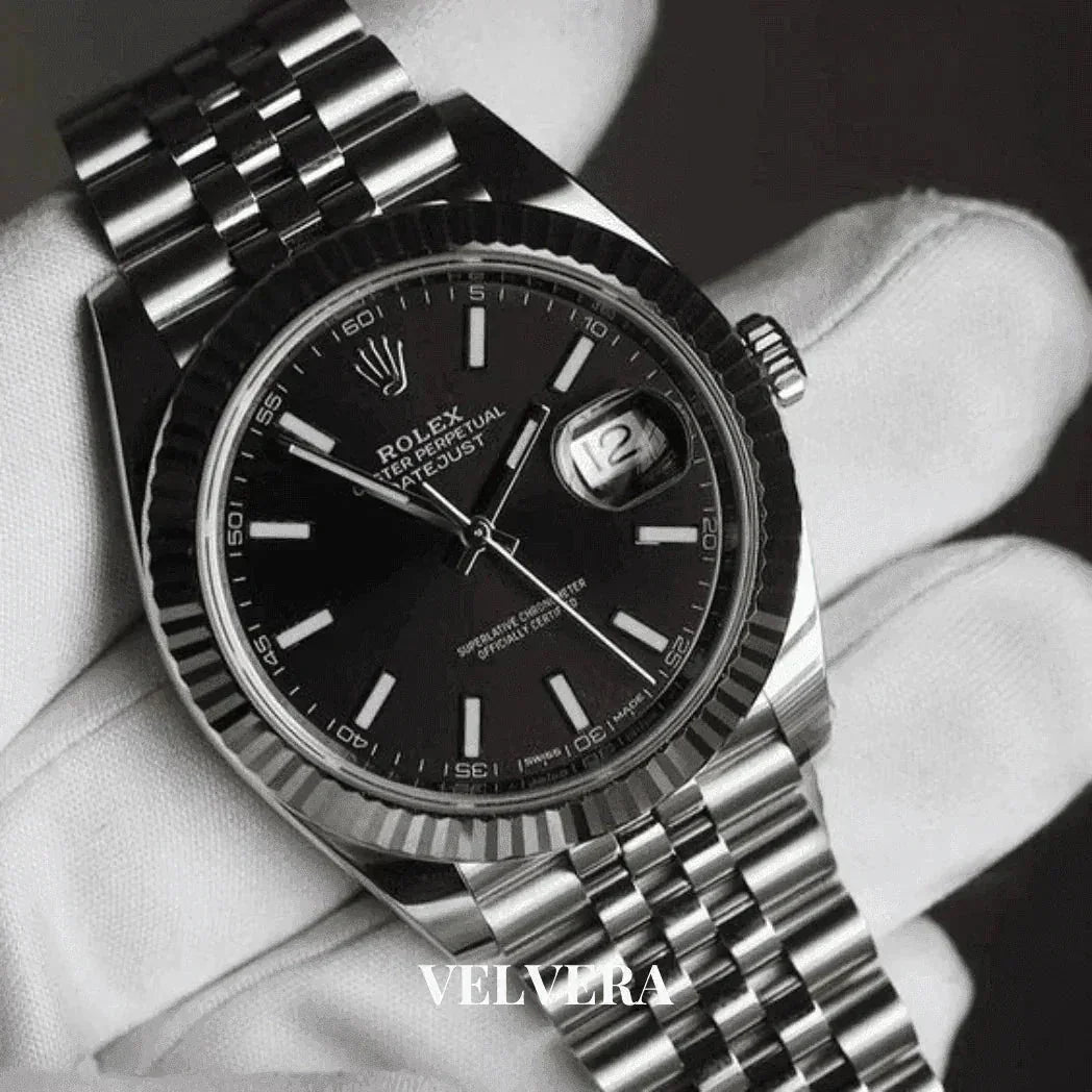 Luxury Rolex Datejust black dial stainless steel watch held by white gloved hand, Velvera logo