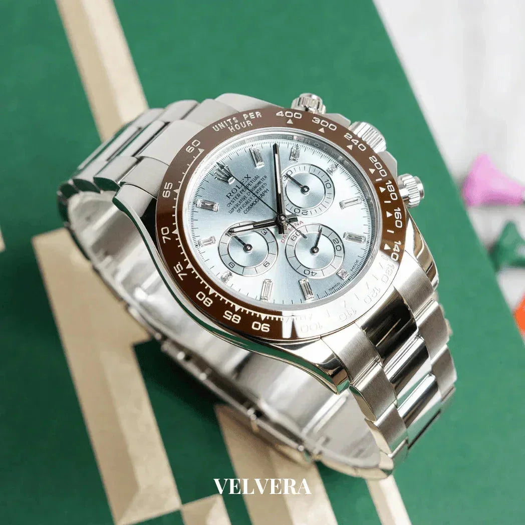 Luxury silver chronograph watch with light blue dial on green textured background, Velvera