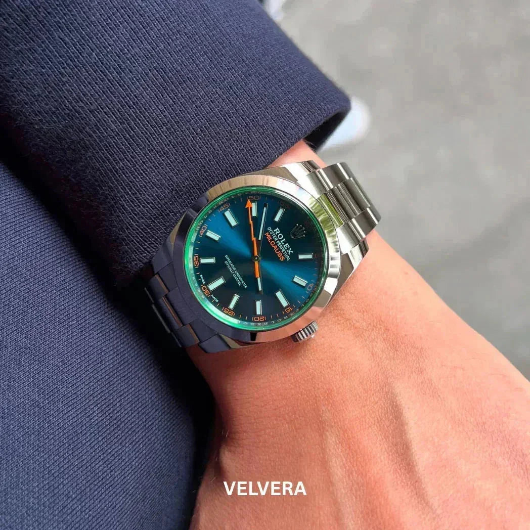 Rolex Milgauss watch with blue dial on wrist, stainless steel band, suited arm, VELVERA branding