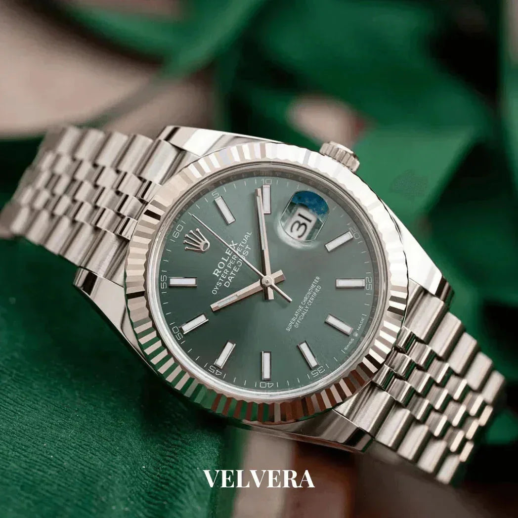 Silver Rolex Datejust watch with green dial on green background, luxury timepiece by Velvera