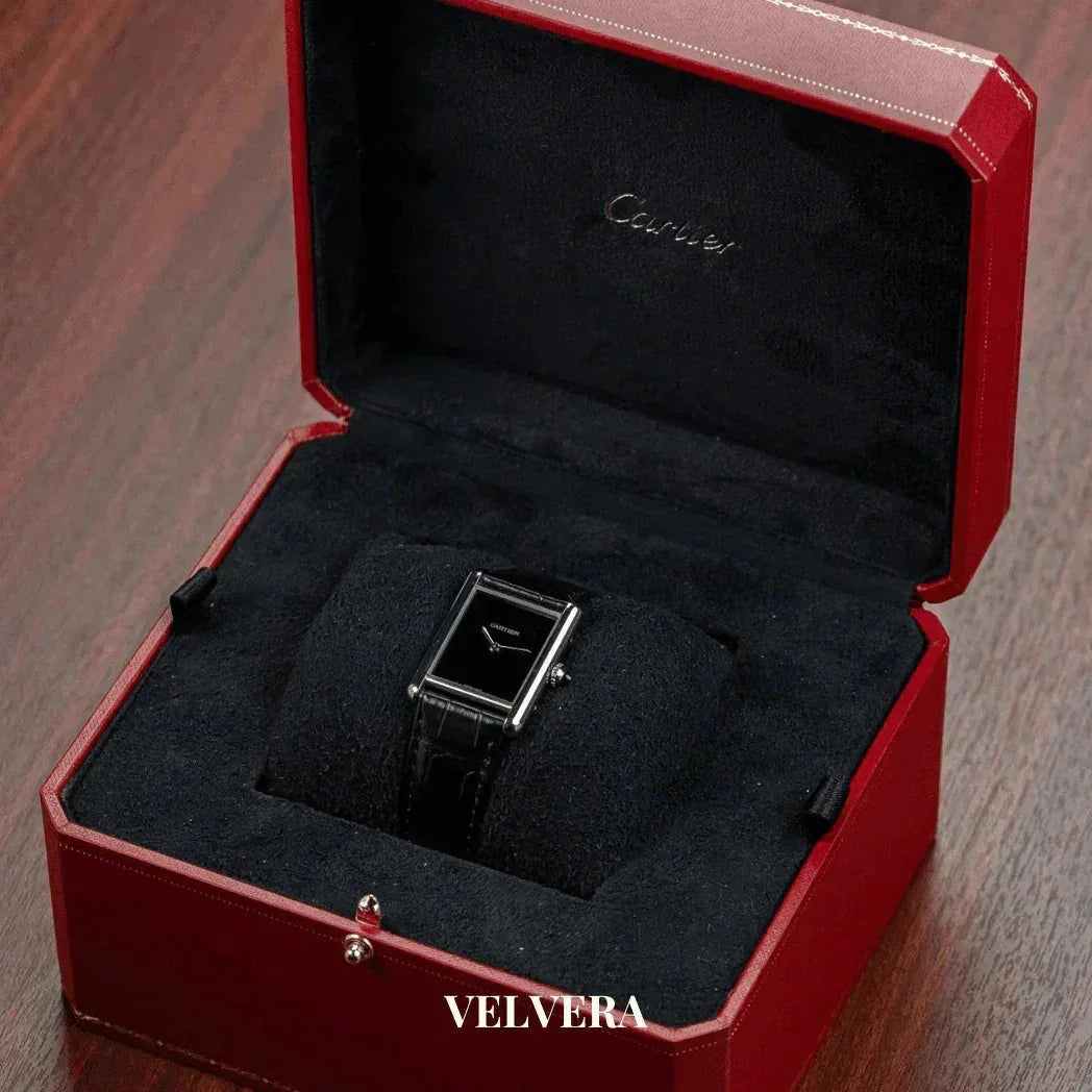 Cartier black leather watch in red luxury box on wooden surface, Velvera branding visible
