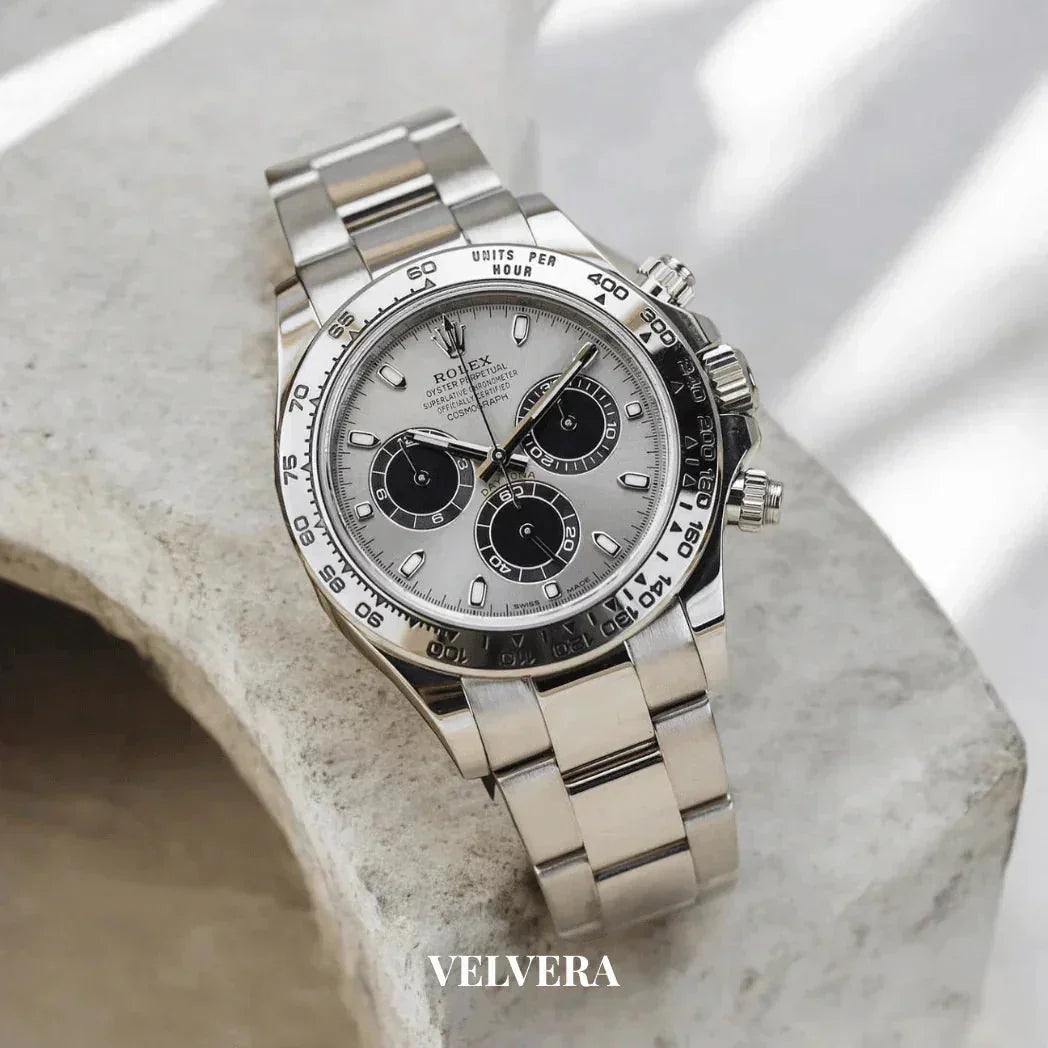 Rolex Daytona stainless steel chronograph watch on marble surface, Velvera branding