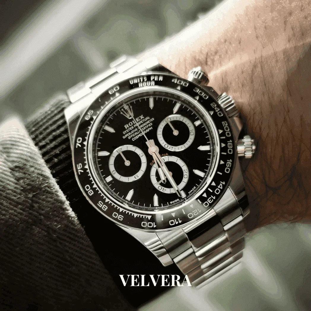 Stainless steel Rolex Daytona watch with black dial on wrist, Velvera branding visible