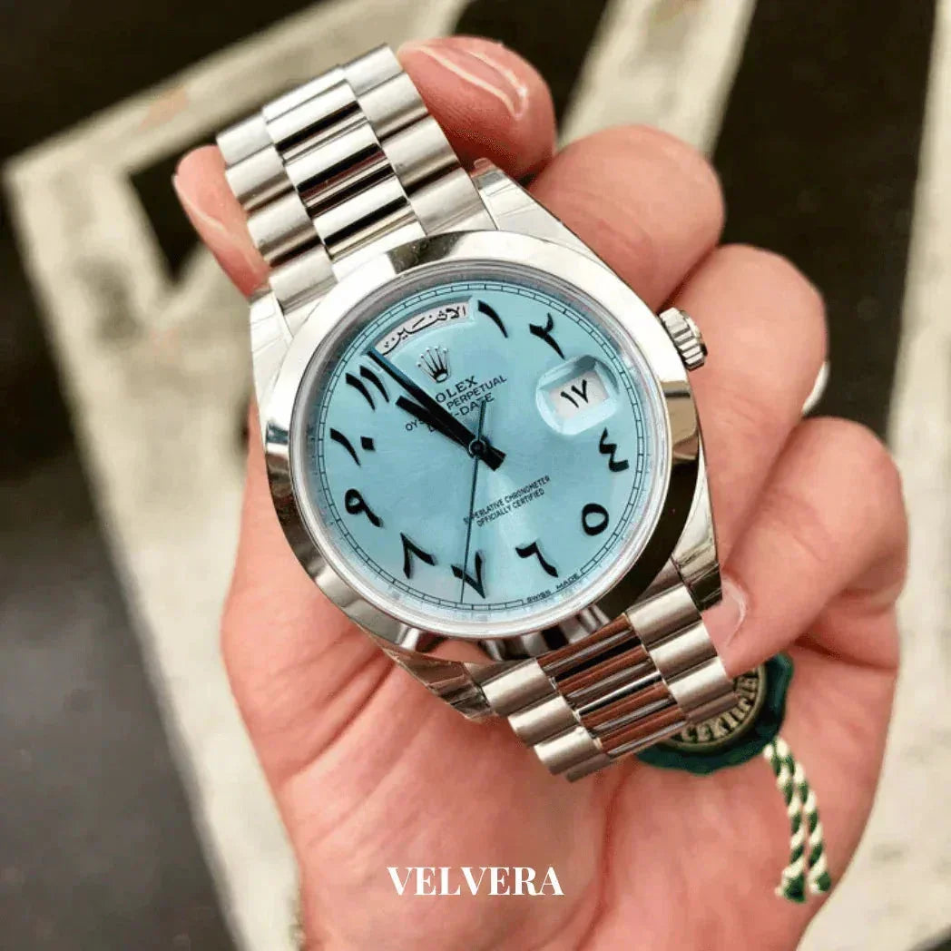 Rolex watch with Arabic numerals, ice blue dial, stainless steel bracelet, held in hand