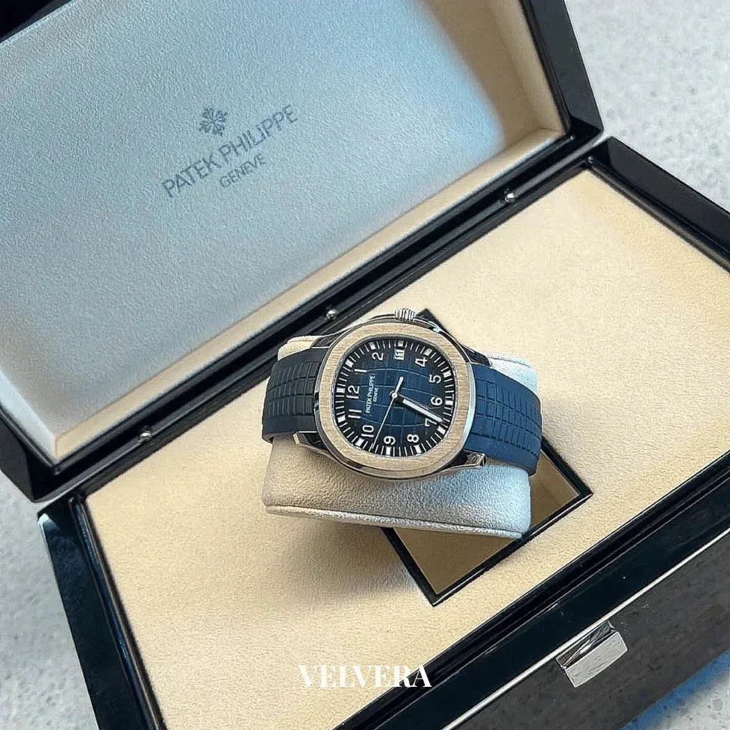 Patek Philippe Aquanaut watch with black strap displayed in branded box, luxury timepiece