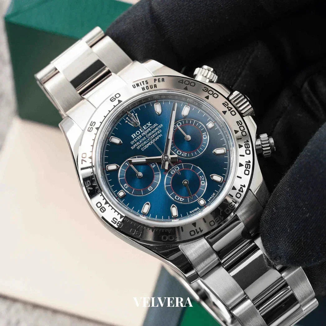 Rolex Daytona stainless steel watch with blue dial and chronograph, held by gloved hand