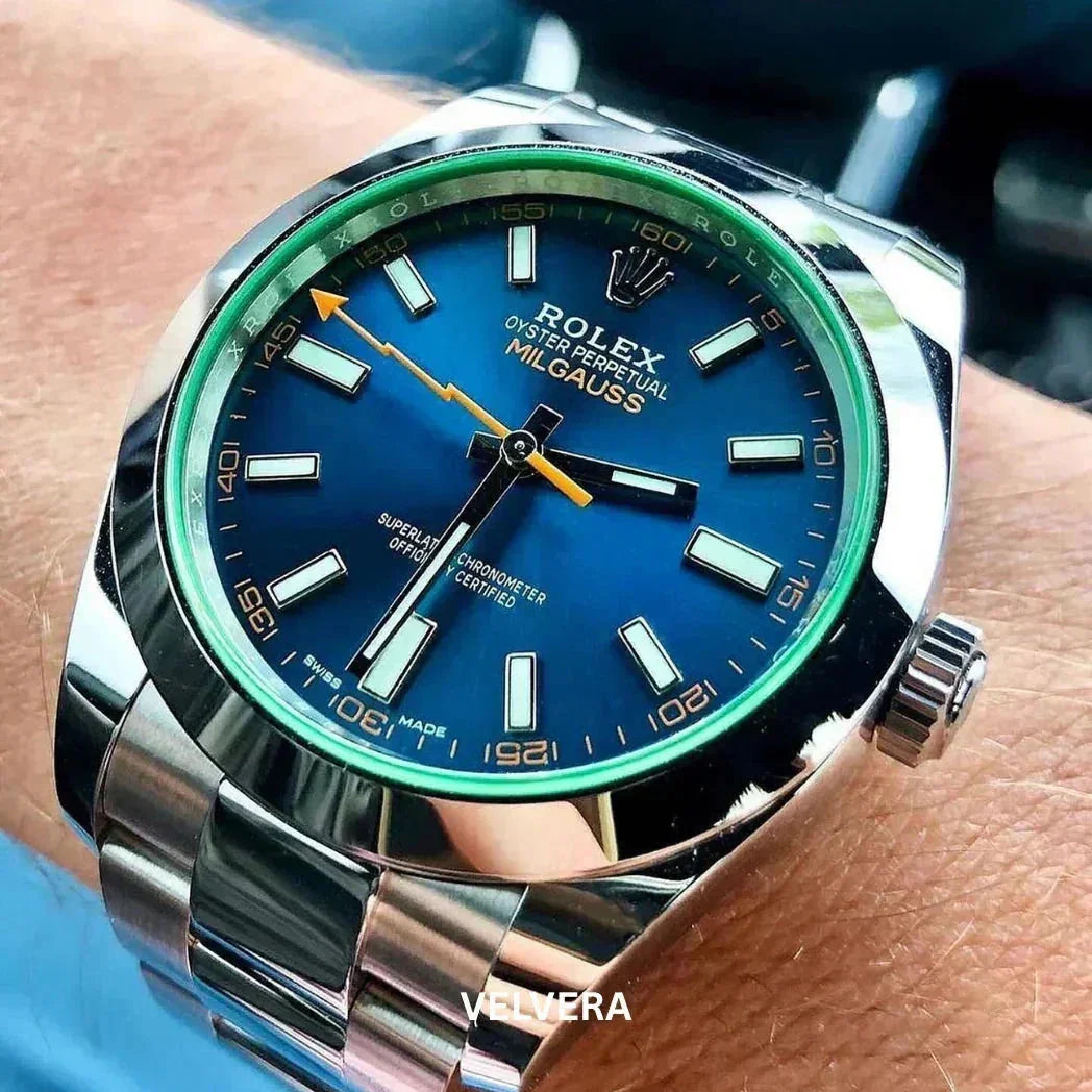 Rolex Milgauss blue dial luxury watch with green bezel on wrist, polished metal bracelet