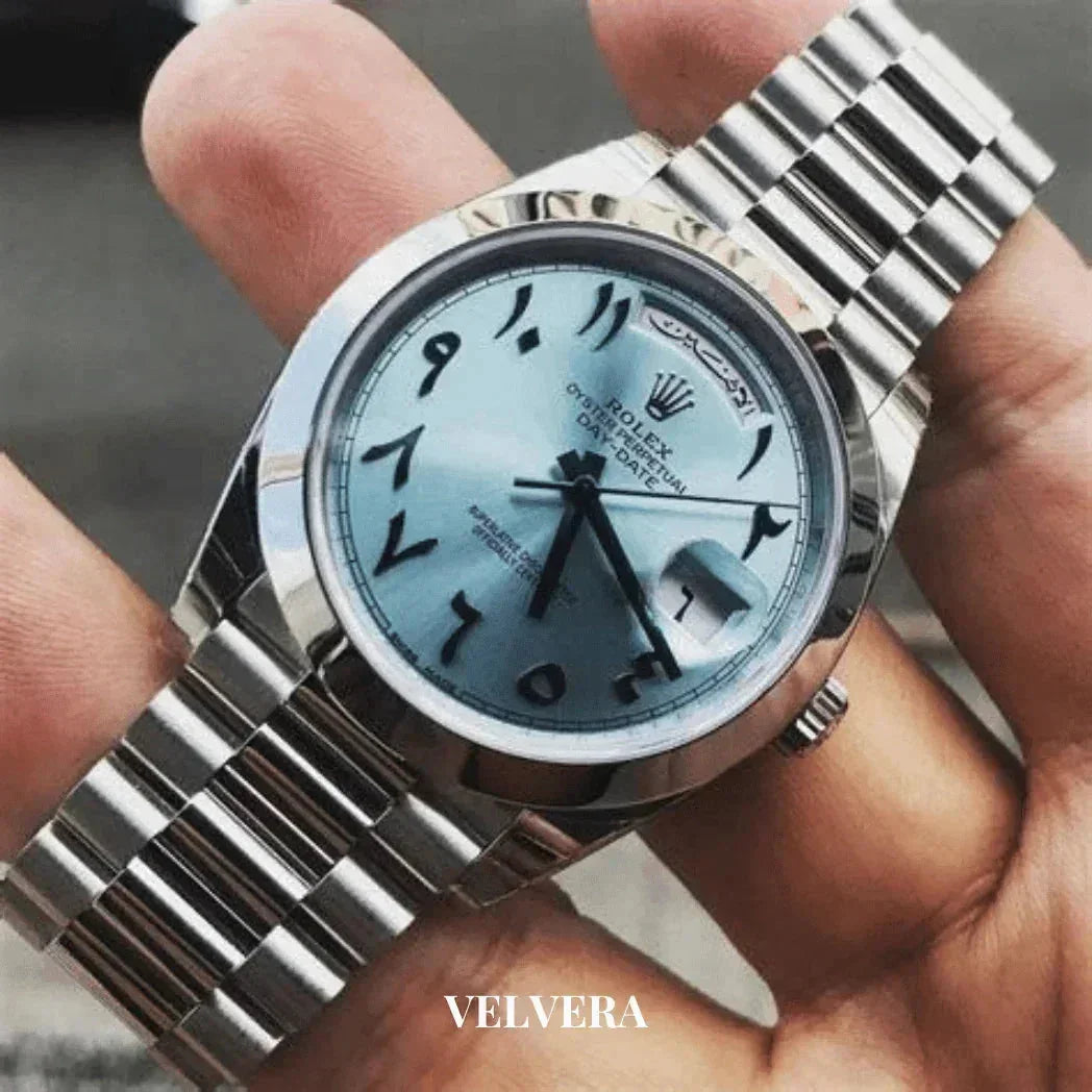 Rolex Oyster Perpetual Day-Date watch with Arabic numerals and silver bracelet held in hand