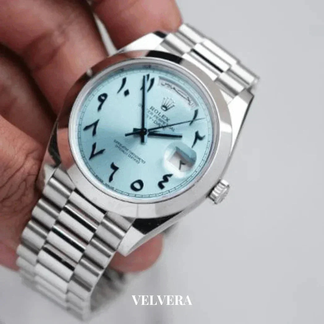 Rolex watch with silver bracelet, ice blue dial, and Arabic numerals held in hand