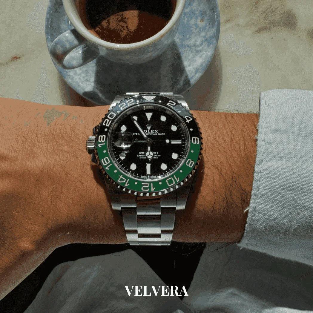 Luxury Rolex GMT-Master II watch on wrist, coffee cup on marble table, Velvera branding