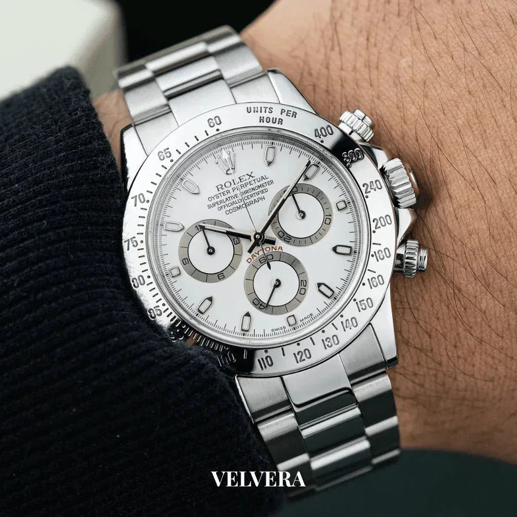 Silver Rolex Daytona chronograph watch with white dial on wrist, Velvera branding visible