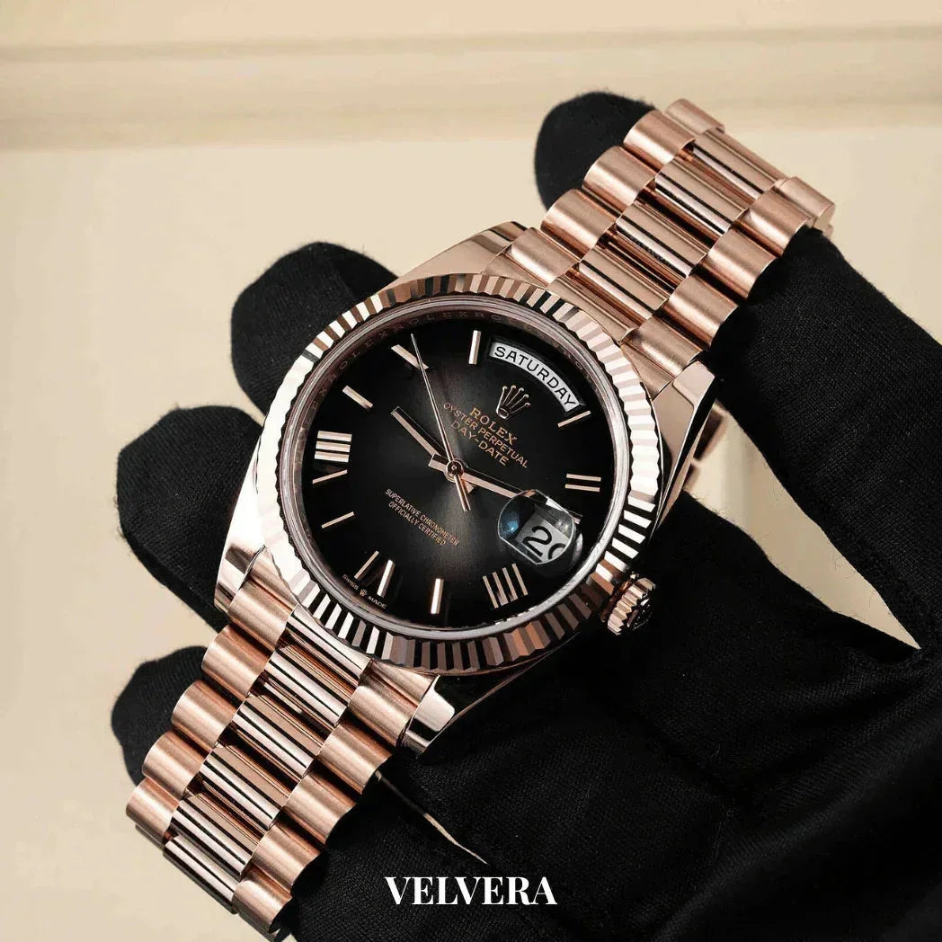 Rose gold Rolex Day-Date watch with black dial held in gloved hand, VELVERA branding